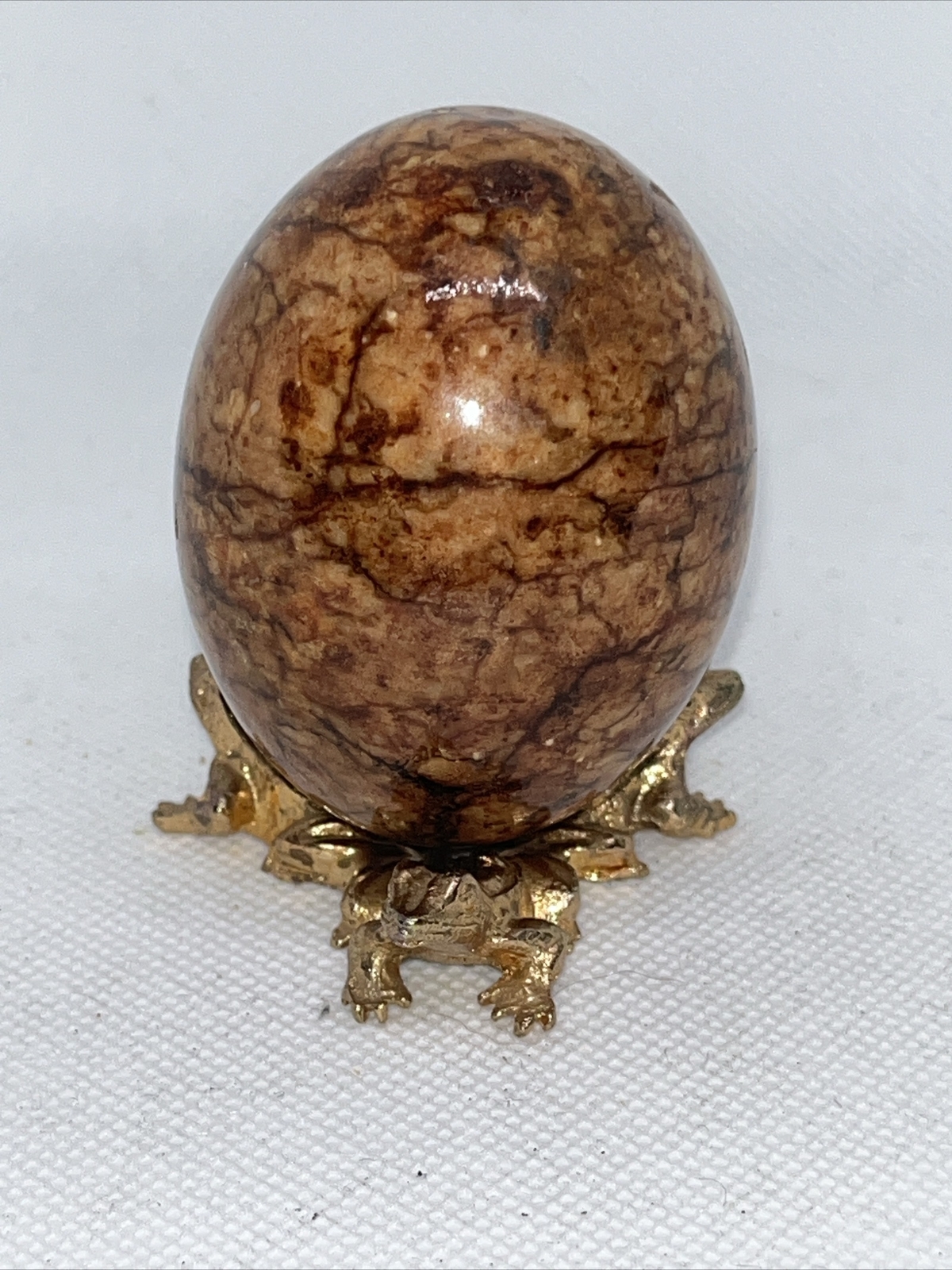 Alabaster stone egg on a metal stand