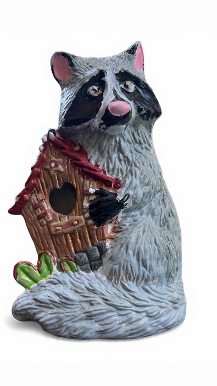 Hand painted ceramic raccoon holding a birdhouse as both a figure and holder