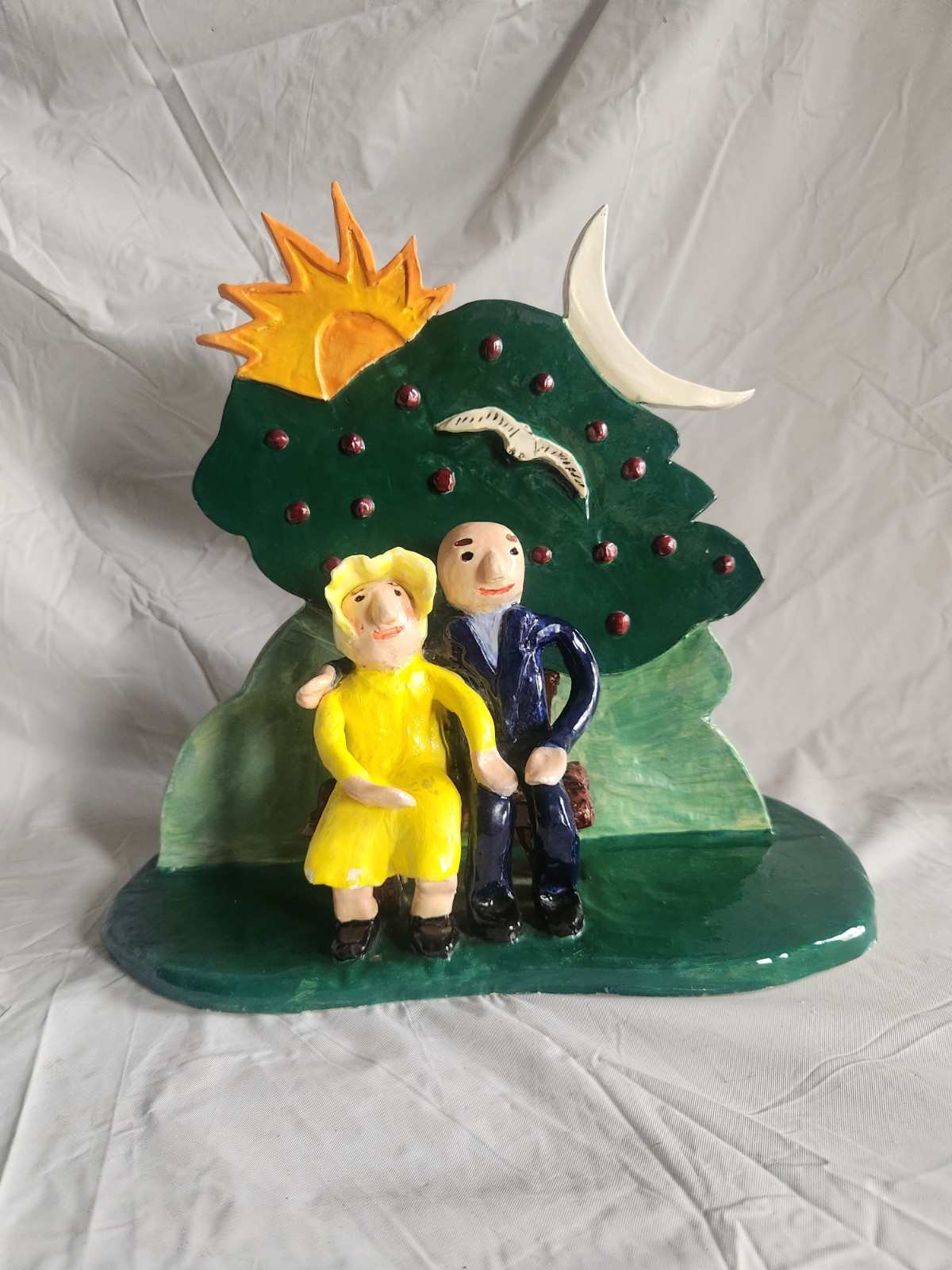 Handcrafted Ceramic Folk Art Style Figure of Couple Sitting on Bench Under Tree