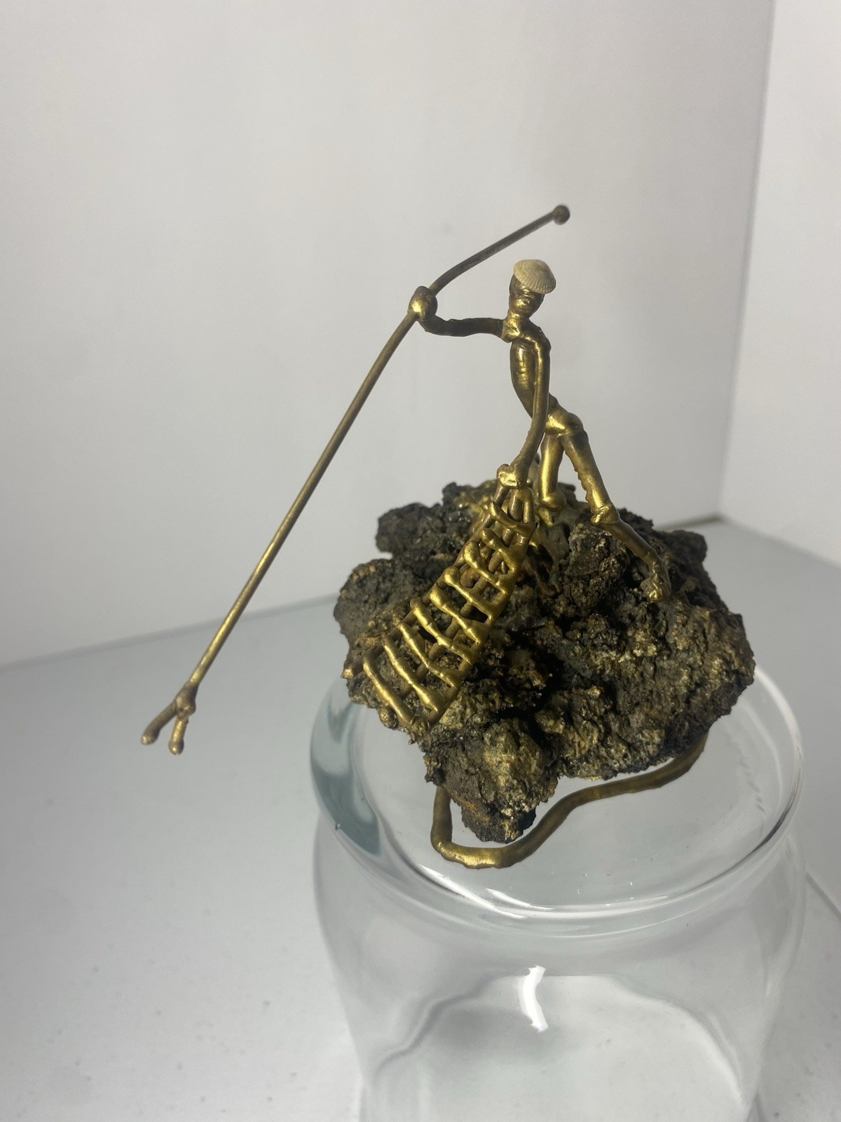 Abstract Brass Fisherman on Lava Rock