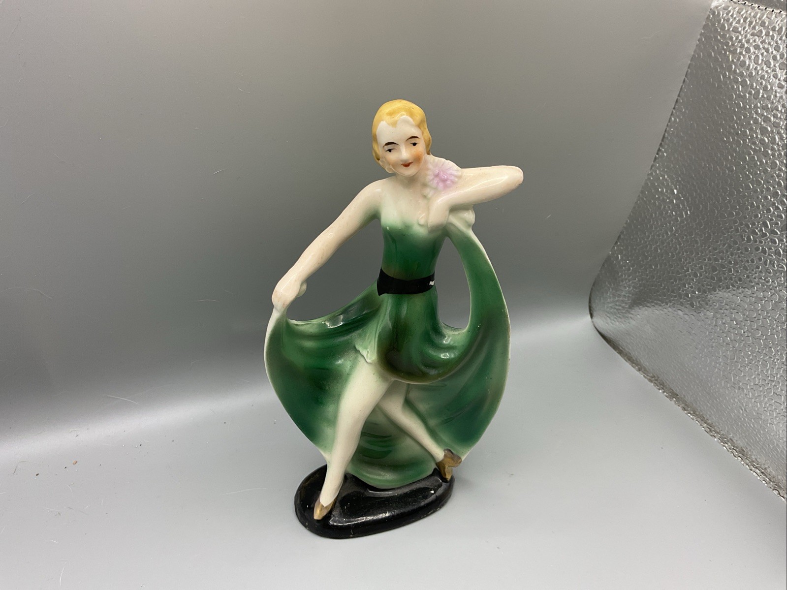 Art Deco ceramic figurine of a dancing woman in a green dress. 7”