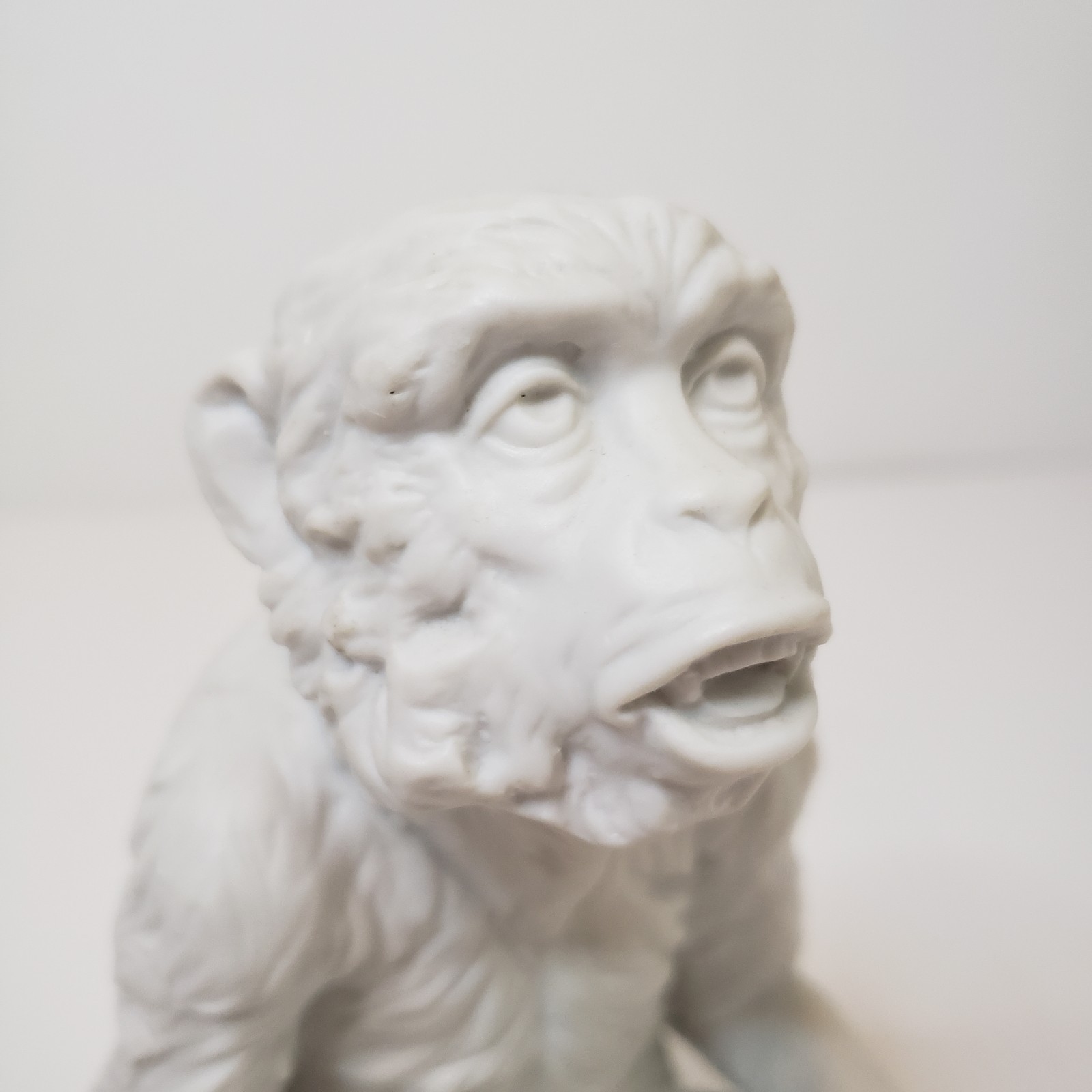 White Bisque Porcelain Sitting Monkey Holding Rock Figurine Vintage