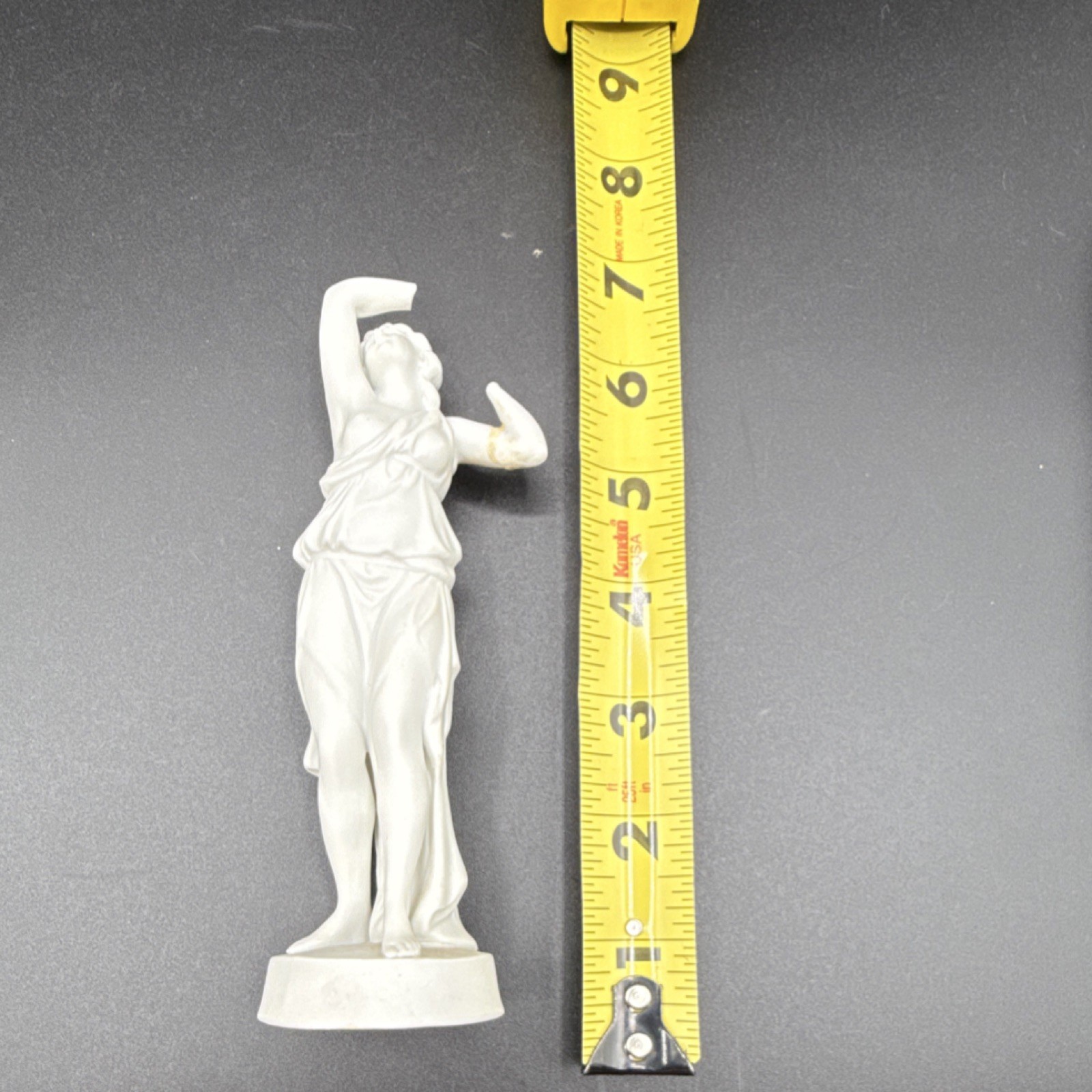 White porcelain figurine of a woman with carvings and matte finish, 6 in