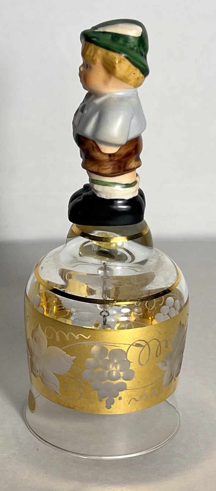 Vintage Goebel crystal bell featuring a porcelain figurine of a young boy on top