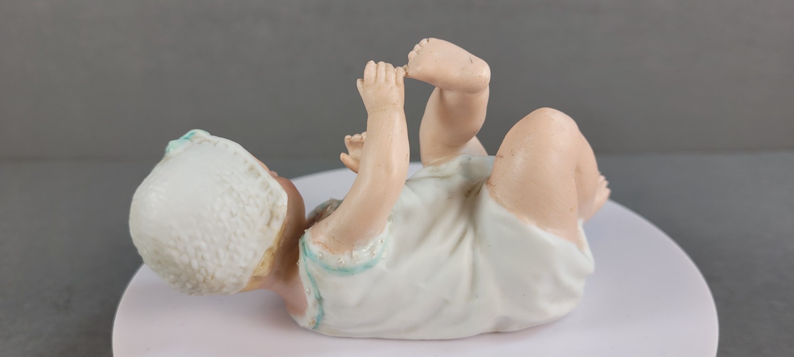 ANTIQUE GEBRUDER HEUBACH BISQUE PIANO BABY BOY W/BONNET PLAYING W/TOES 4.5″ LONG