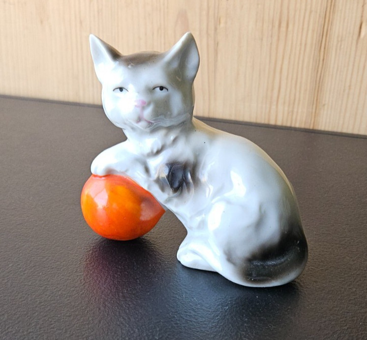 KITTY CAT PLAYING WITH ORANGE BALL. WHITE BLACK CERAMIC FIGURE MADE IN JAPAN.
