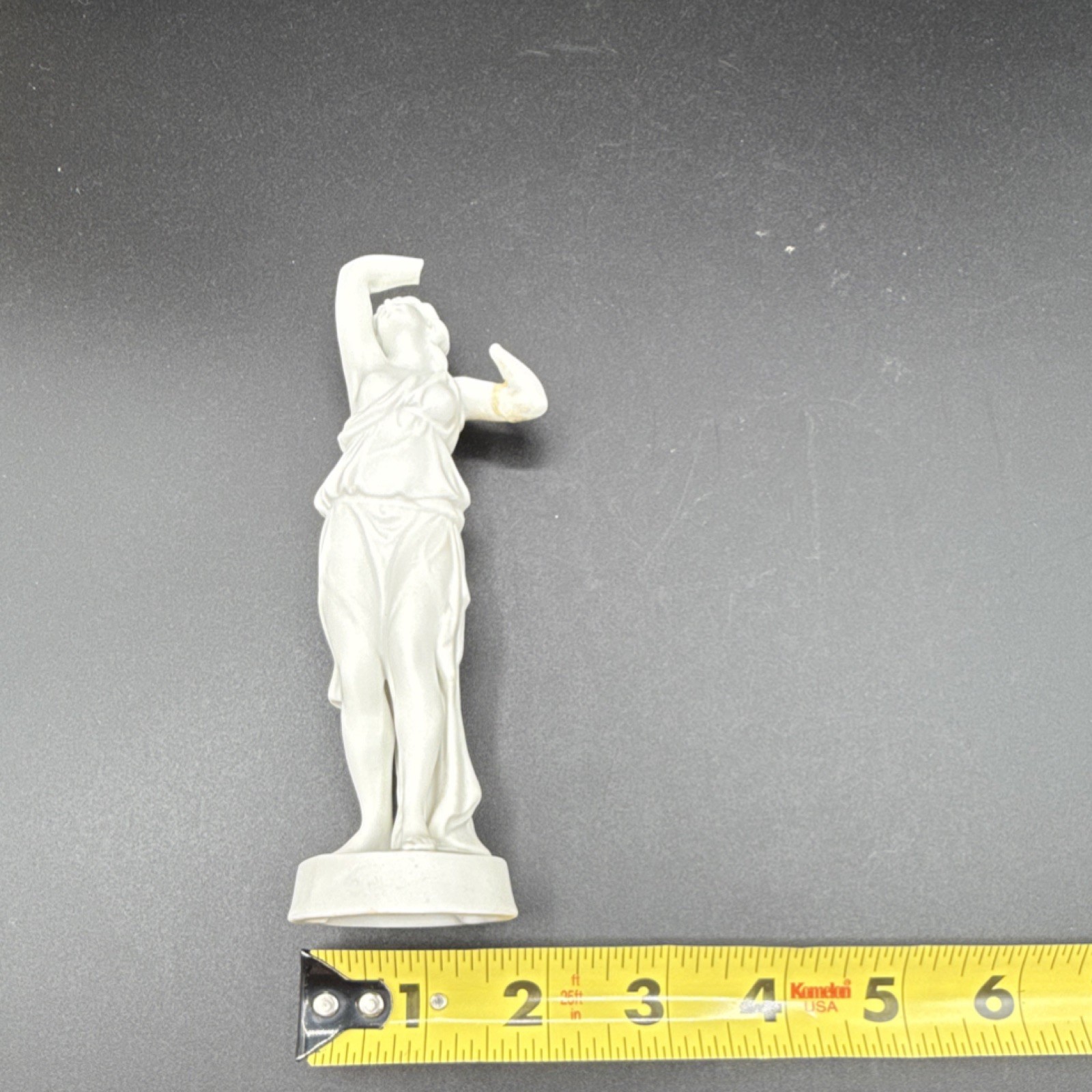 White porcelain figurine of a woman with carvings and matte finish, 6 in