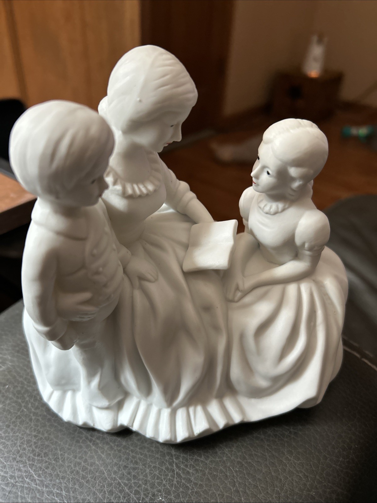 Porcelain Figurine Depicts A Scene of A Mother and Children Reading Together.