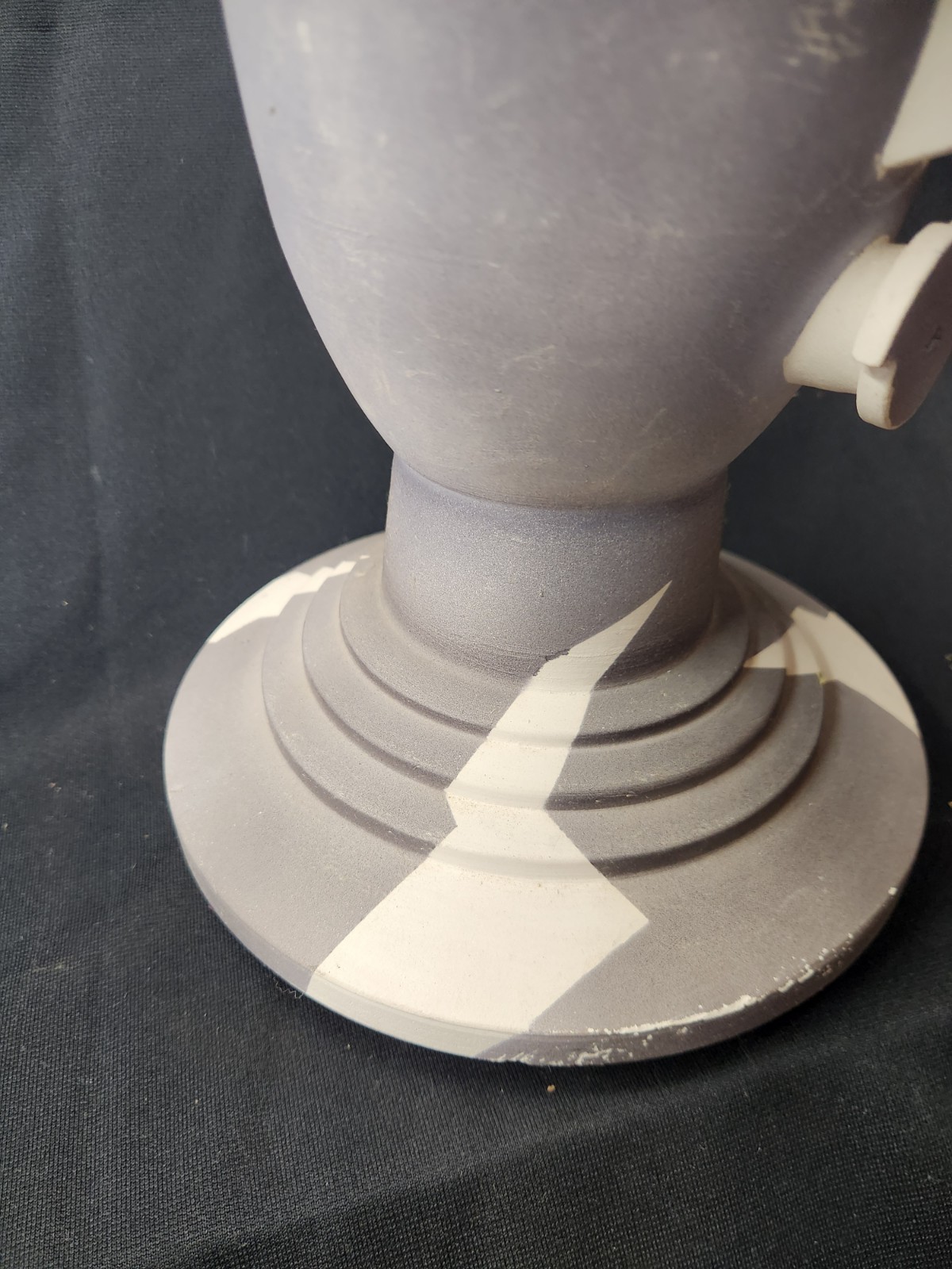 Design: The piece features an abstract, modernist design with simplified facial