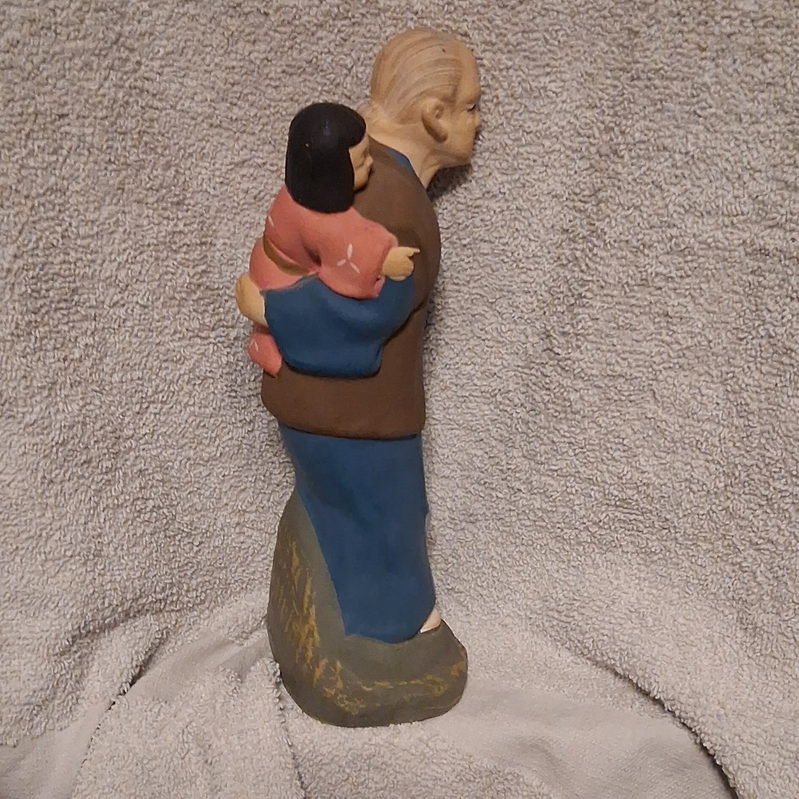 Uncommon Ceramic Hand Painted Figurine Of An Elderly Man Carrying A Small Child