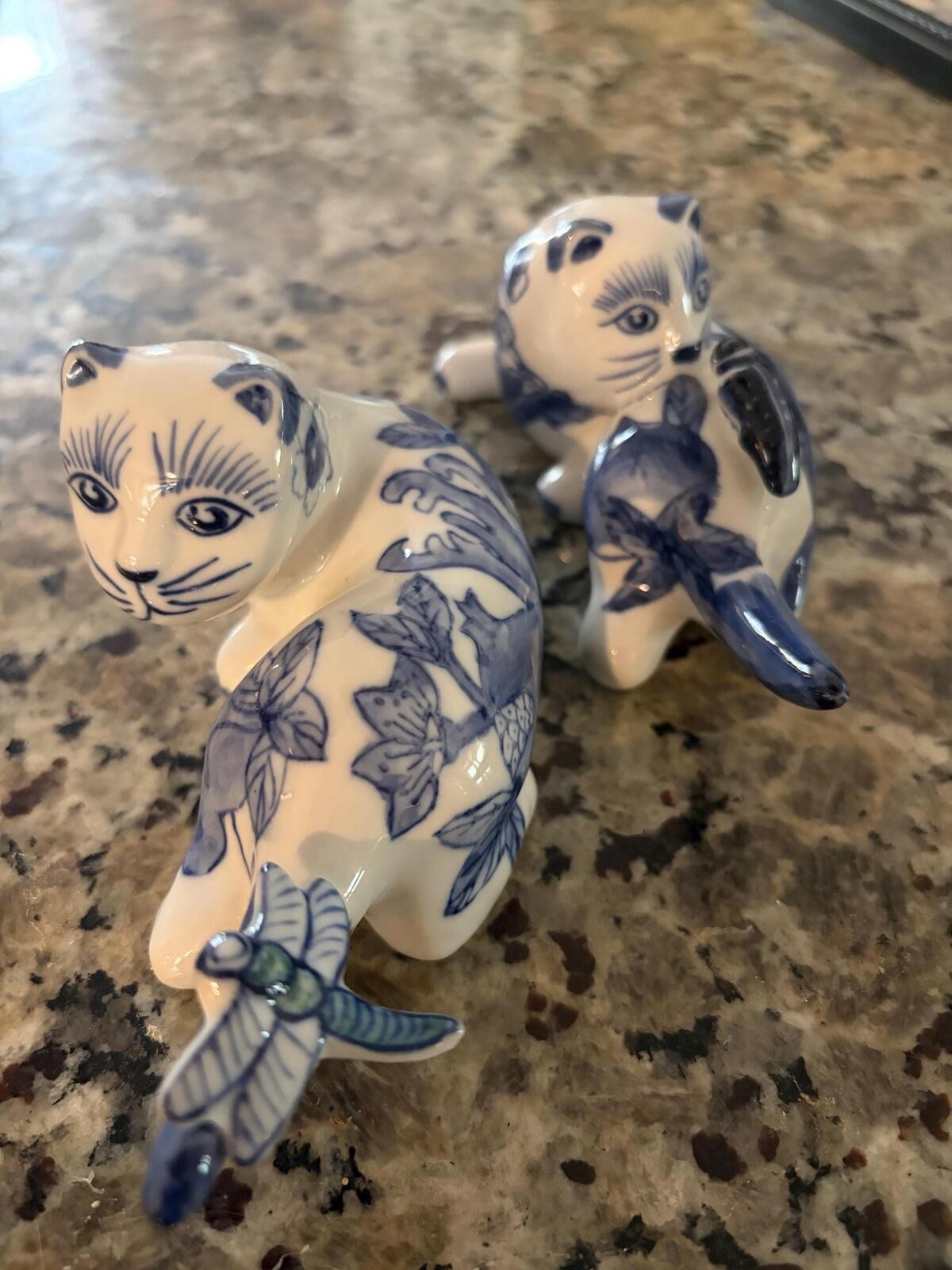 A vintage blue and white porcelain cat figurine with floral motifs.Set of 2