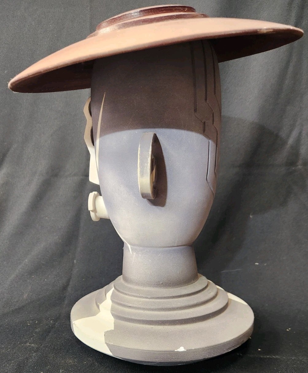 Design: The piece features an abstract, modernist design with simplified facial