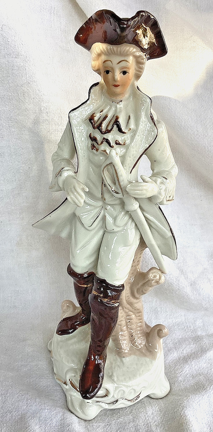 BAROQUE PORCELAIN GENTLEMAN W/ SWORD. LEANING ON A STUMP