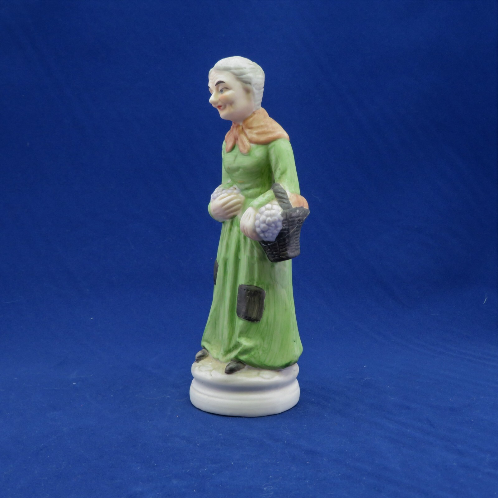 Old Woman Figurine Hand-Painted holding Basket of Grapes 8″ Tall Bisque Vintage