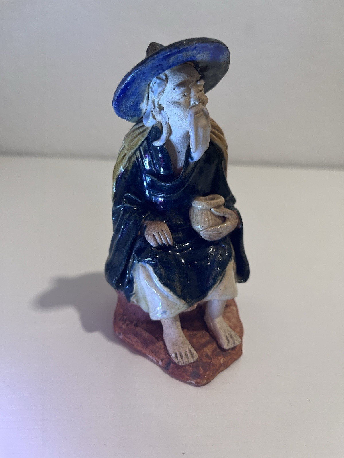 Vintage Chinese Ceramic Seated Mudman Figurine w/ Blue Hat Holding Pot