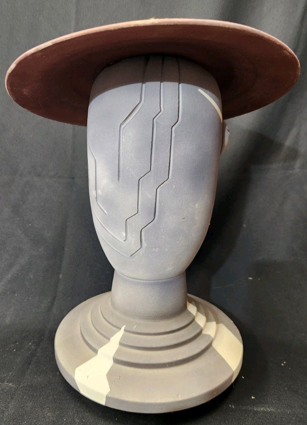 Design: The piece features an abstract, modernist design with simplified facial