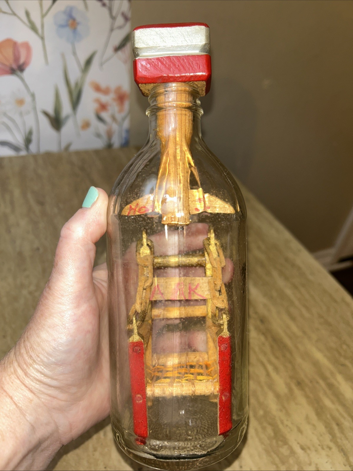 Handmade kinetic sculpture inside a glass bottle with ‘RK’ marking.