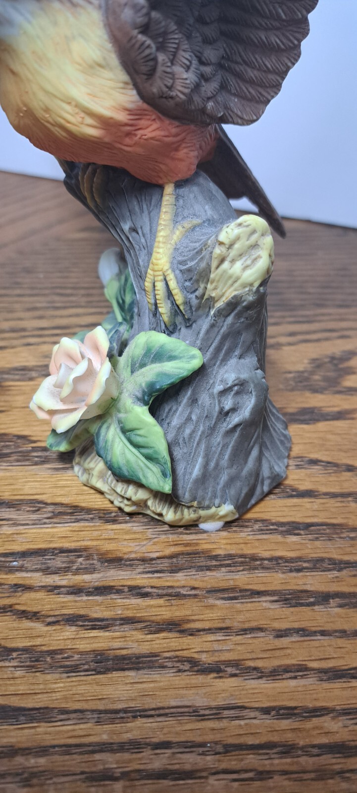 PORCELAIN ROBIN FIGURINE WITH FLOWER 7 5/8” H