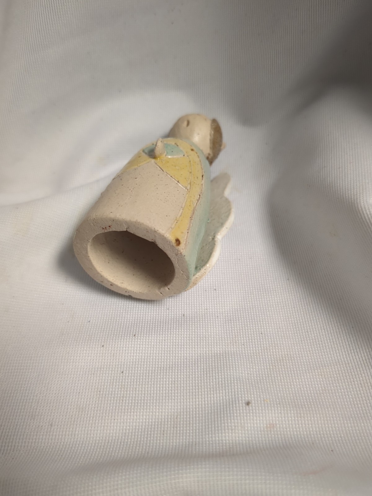 handmade ceramic angel figurine features blue and yellow glaze accents to