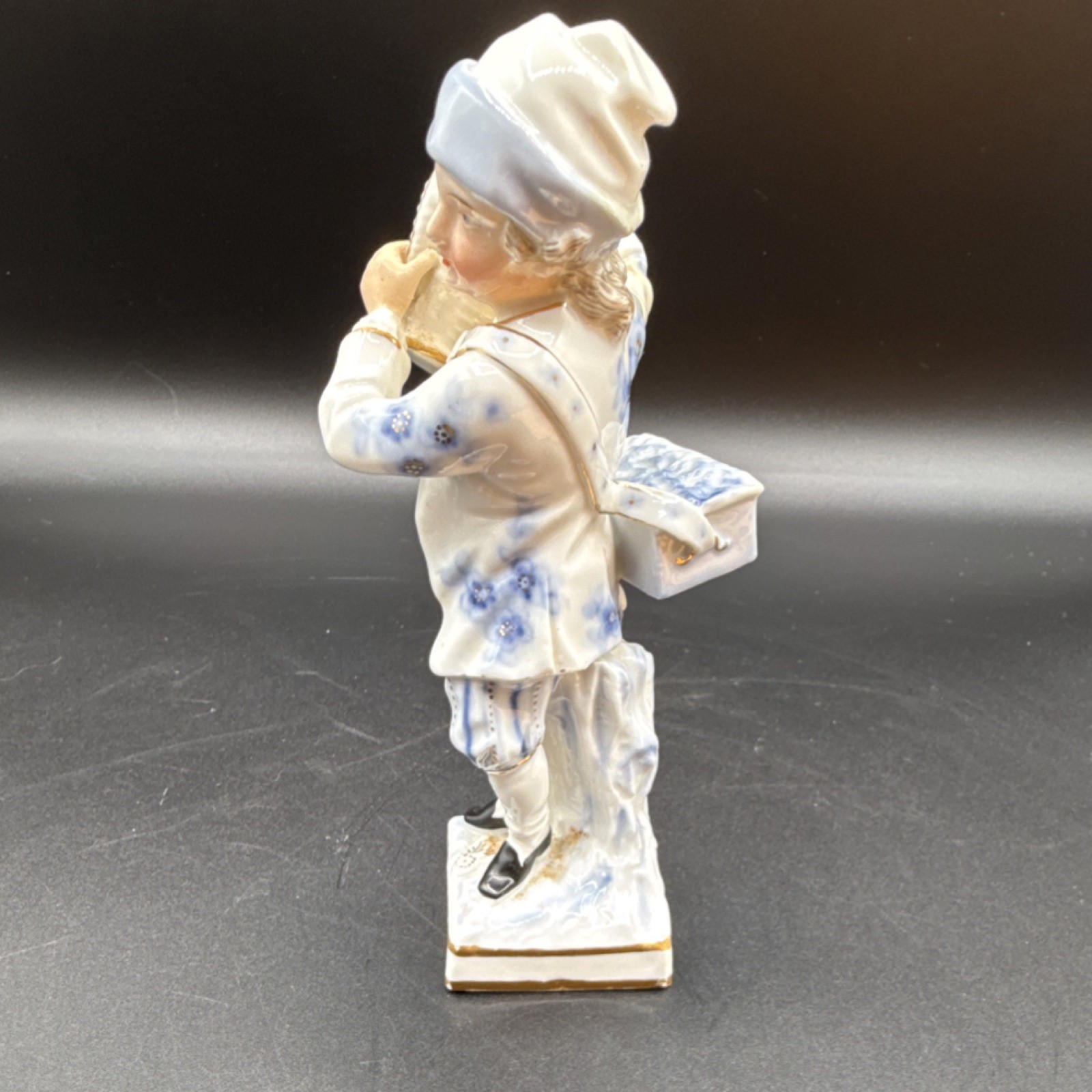 Porcelain figurine ￼young man holding basket, likely German Rococo Revival style