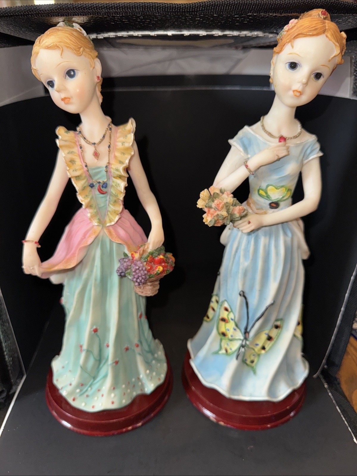 2 Resin Figurines Women Holding Flowers On Wood Bases 12 1/2” Tall