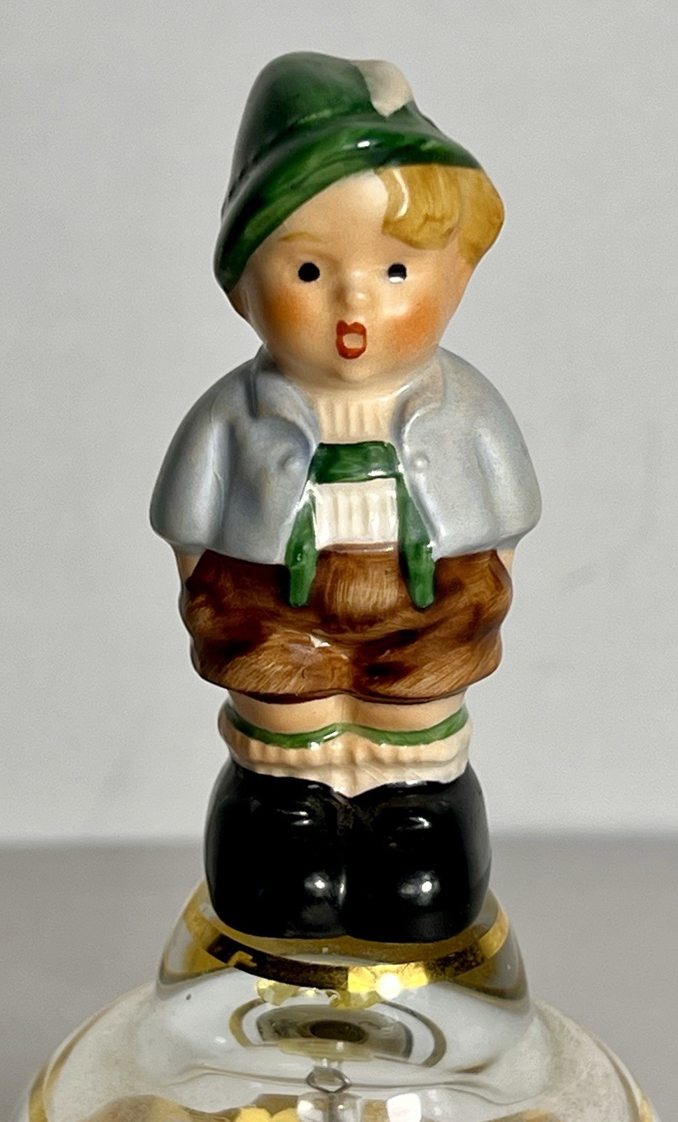 Vintage Goebel crystal bell featuring a porcelain figurine of a young boy on top