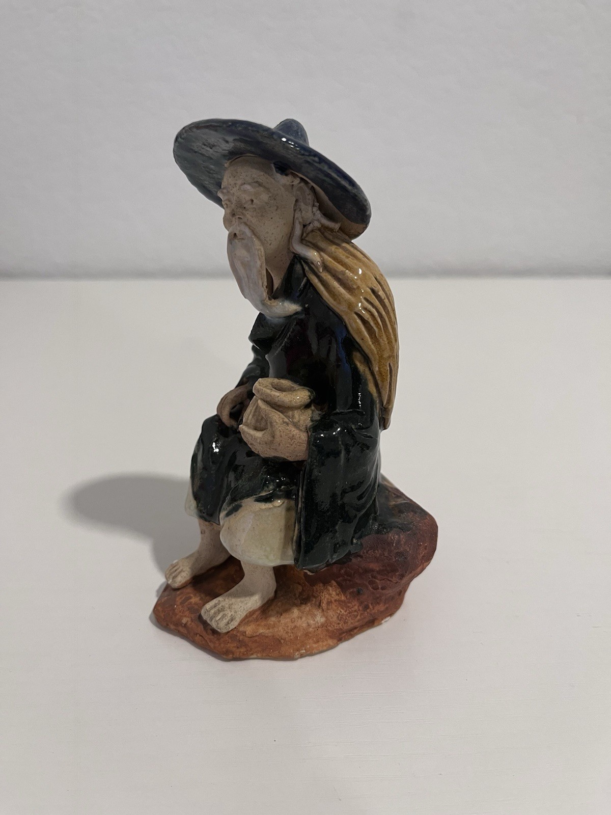 Vintage Chinese Ceramic Seated Mudman Figurine w/ Blue Hat Holding Pot