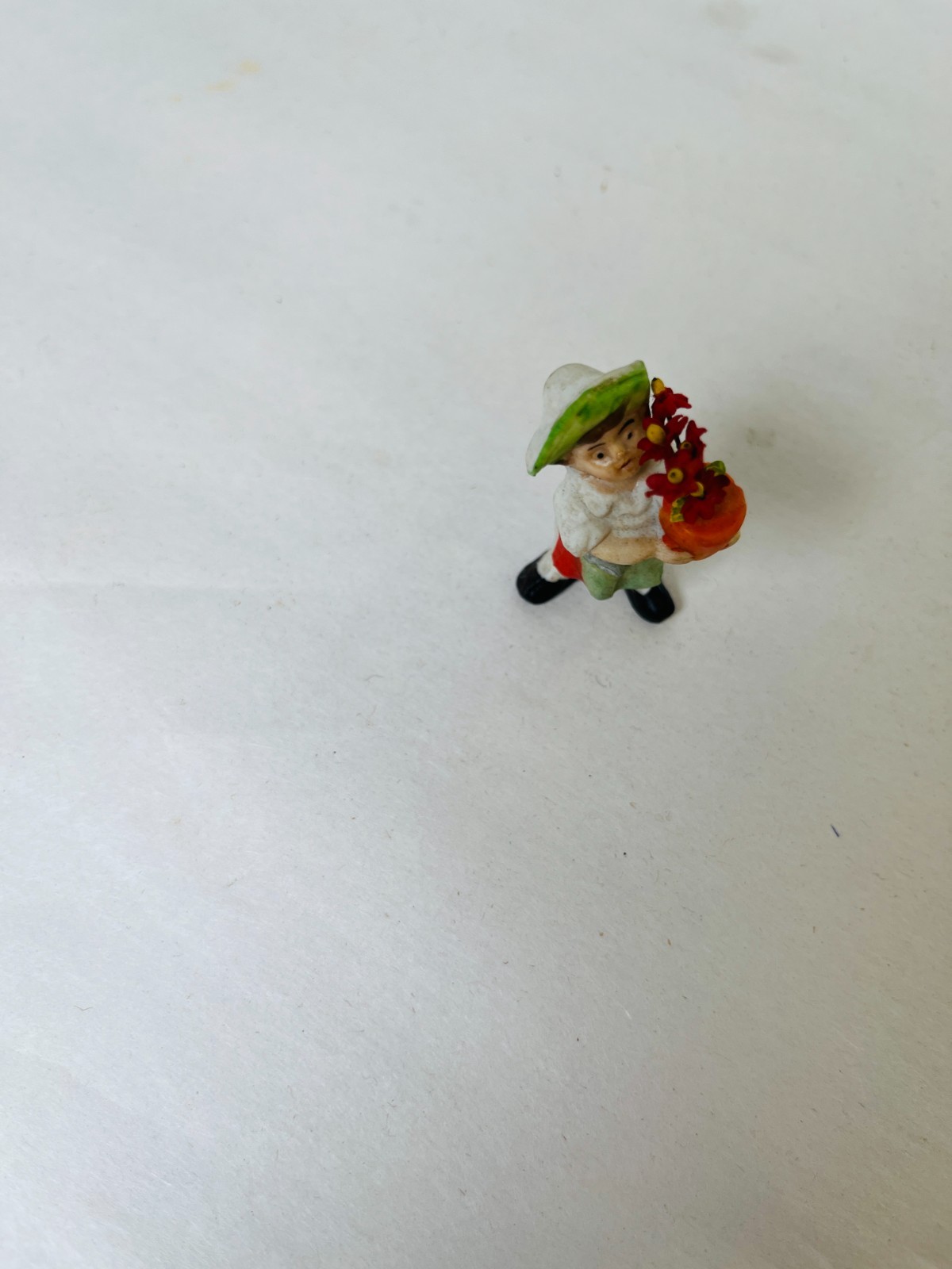 Antique Small porcelain Figure Holding A Pot Of Flowers 2″ Tall
