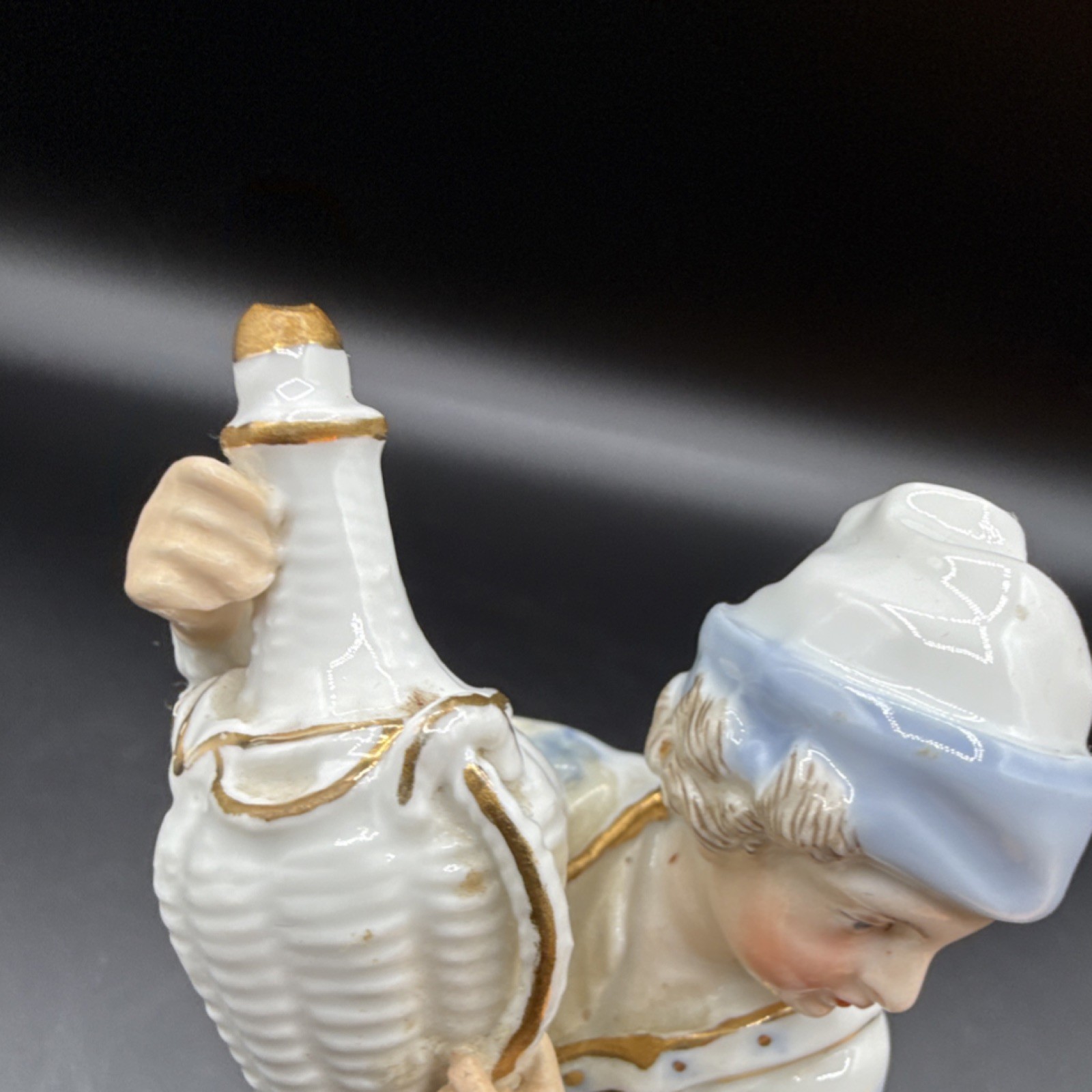 Porcelain figurine ￼young man holding basket, likely German Rococo Revival style