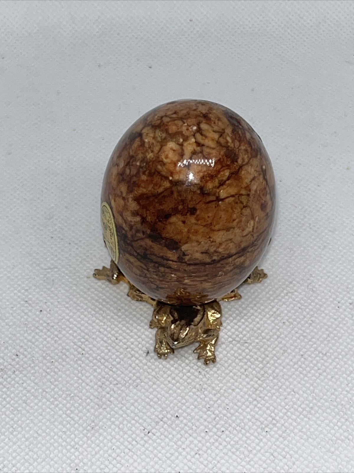 Alabaster stone egg on a metal stand