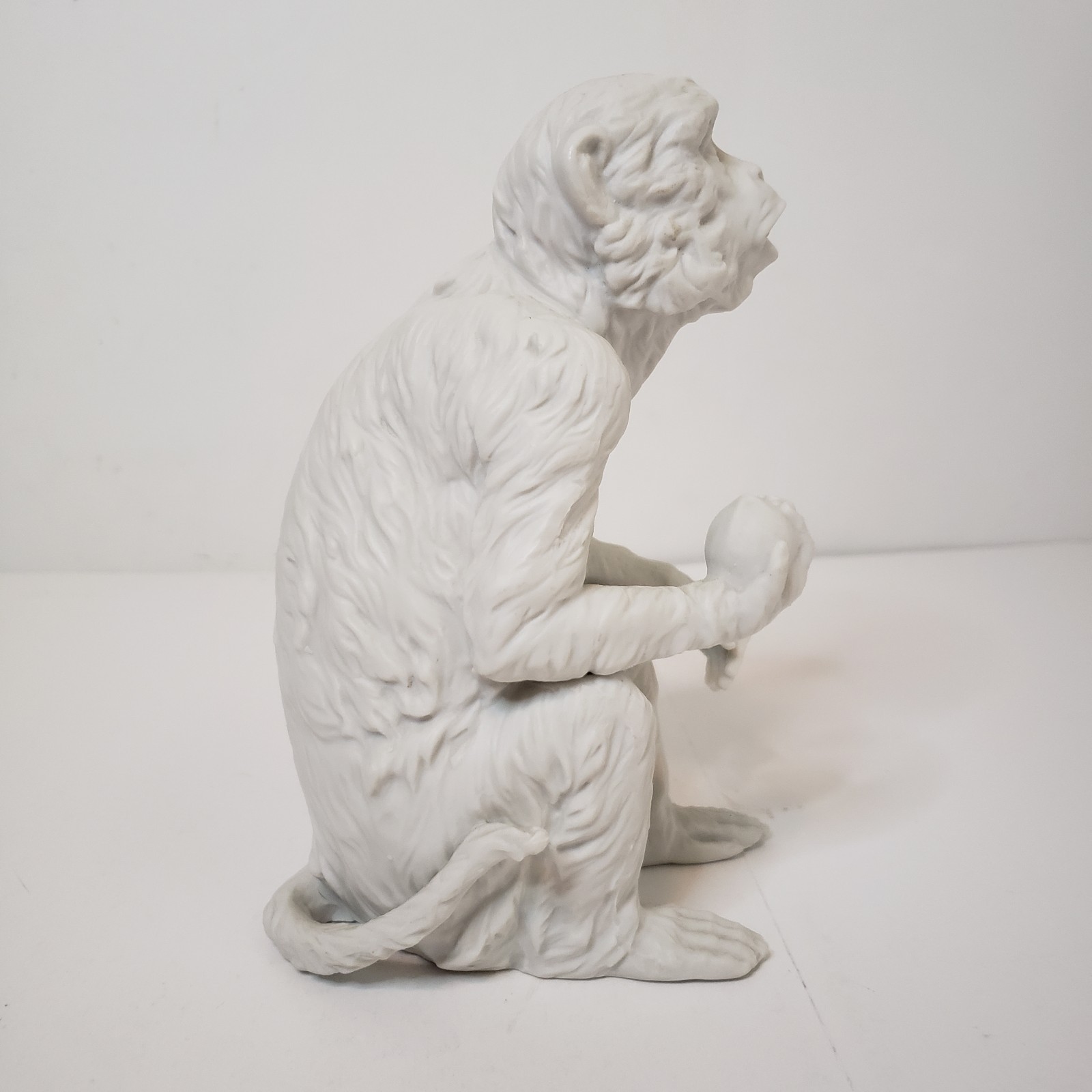 White Bisque Porcelain Sitting Monkey Holding Rock Figurine Vintage