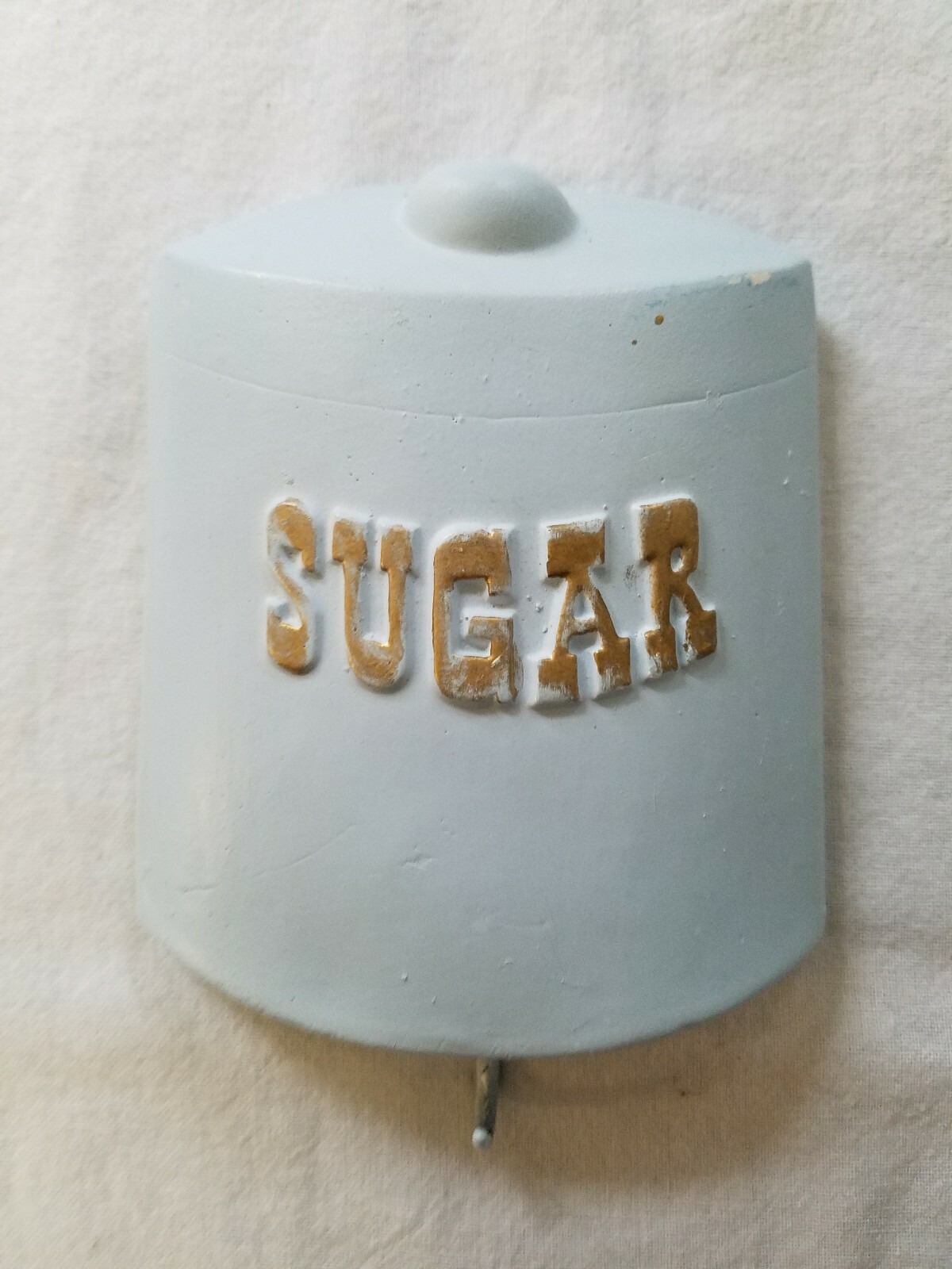 Pale Blue Chalkware or Plaster Wall Hanging w/ Hook at Bottom & “Sugar” on Front