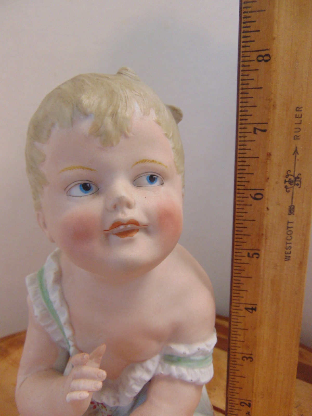 Vtg Ceramic Sitting Piano Baby Figurine w/ Blonde Hair, Blue Eyes Height: 8″