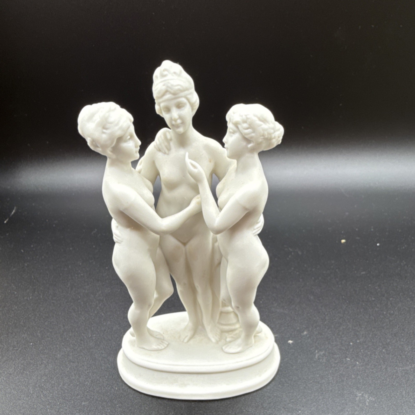White porcelain figurine of three women with matte finish small sculpture