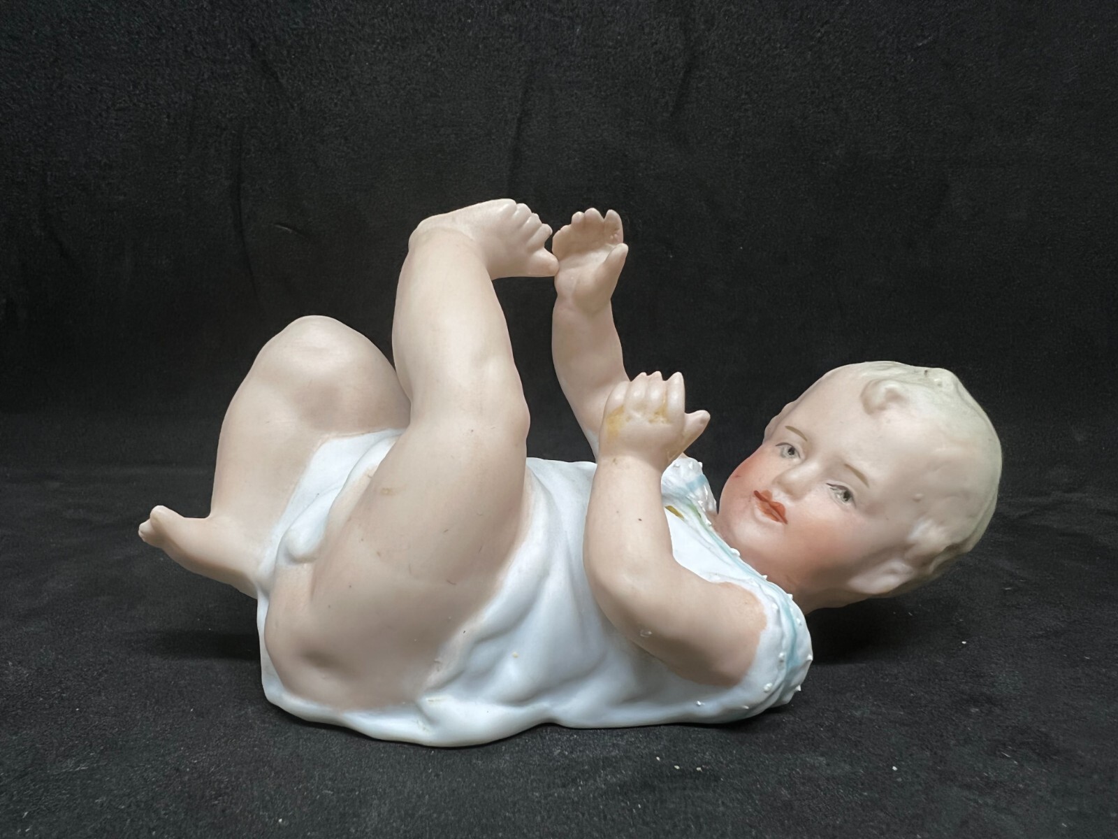 Gebruder Heubach-German Porcelain Bisque-Lying On Back Piano Baby–4 1/2″ Length