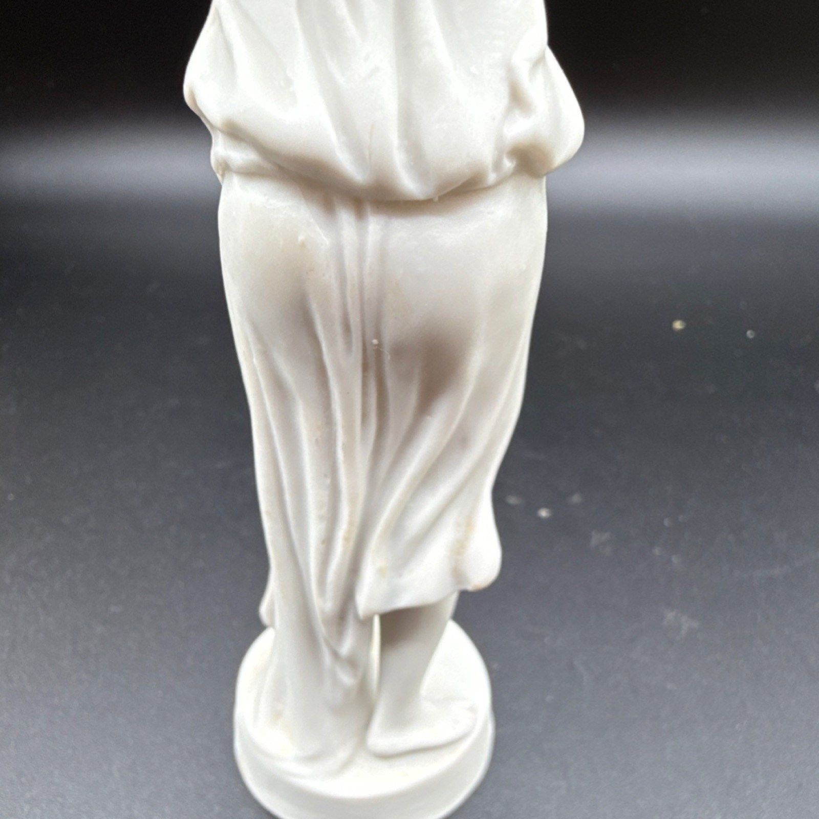 White porcelain figurine of a woman with carvings and matte finish, 6 in