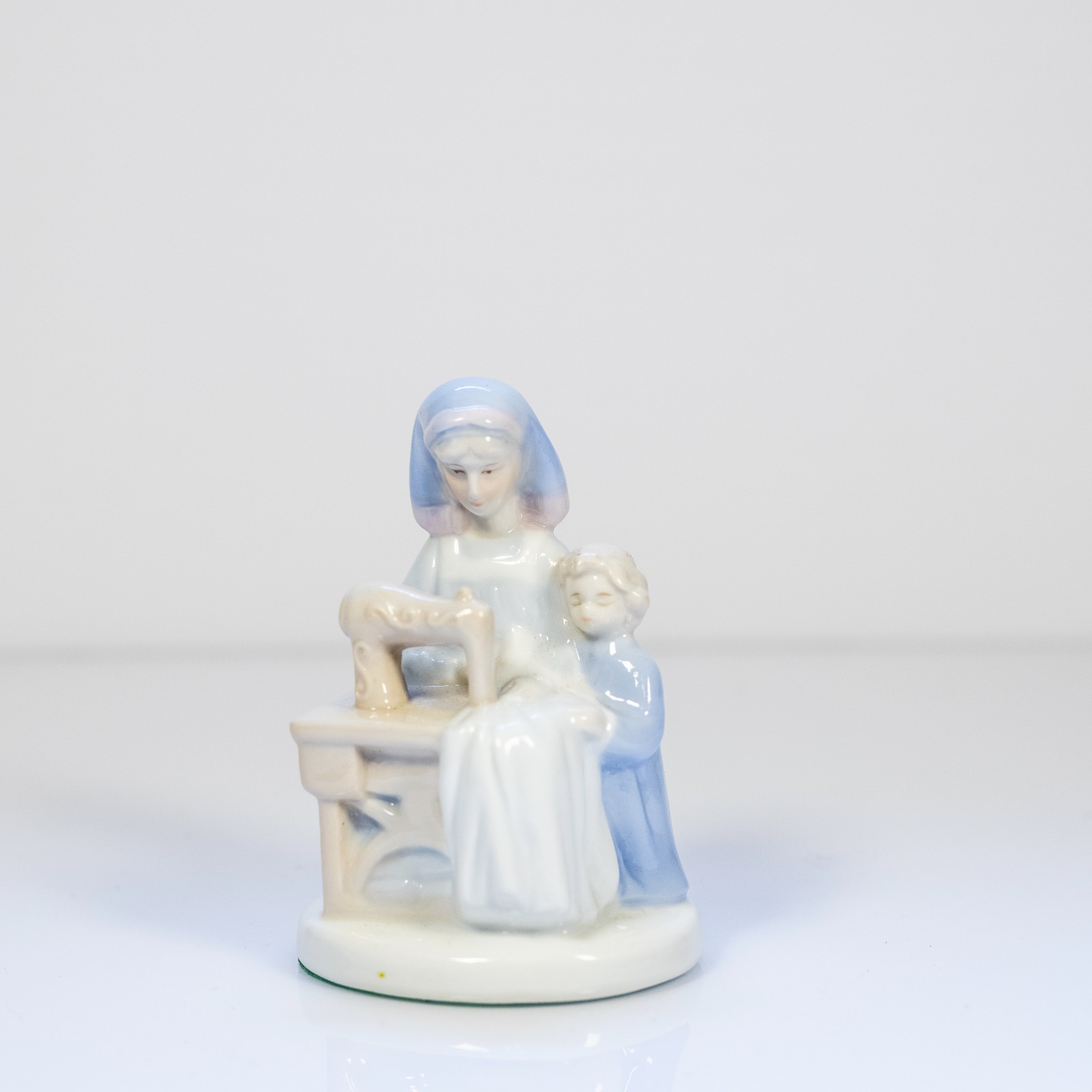 K’s Collectible Porcelain figure, Mother and child at a sewing machine