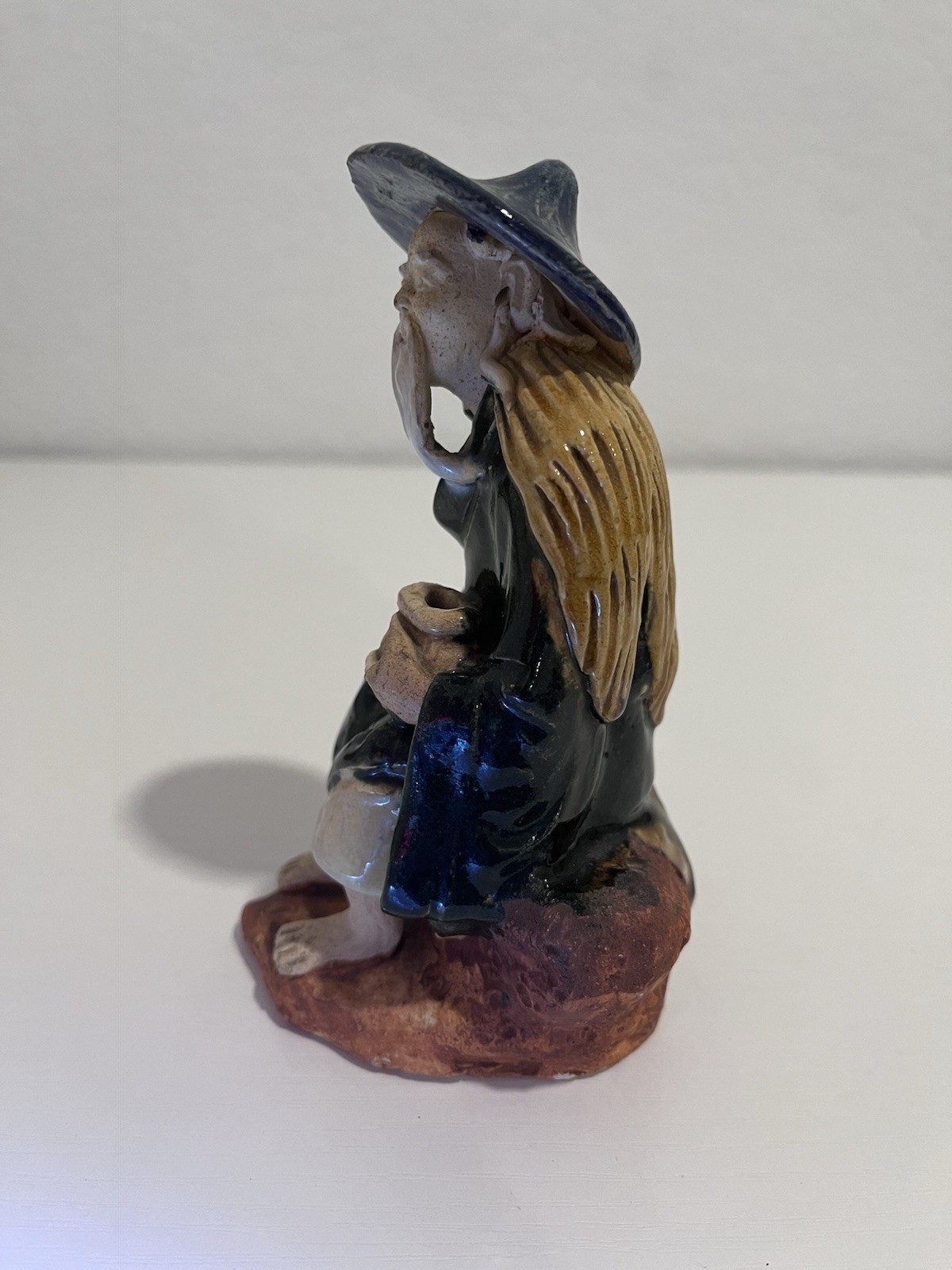 Vintage Chinese Ceramic Seated Mudman Figurine w/ Blue Hat Holding Pot
