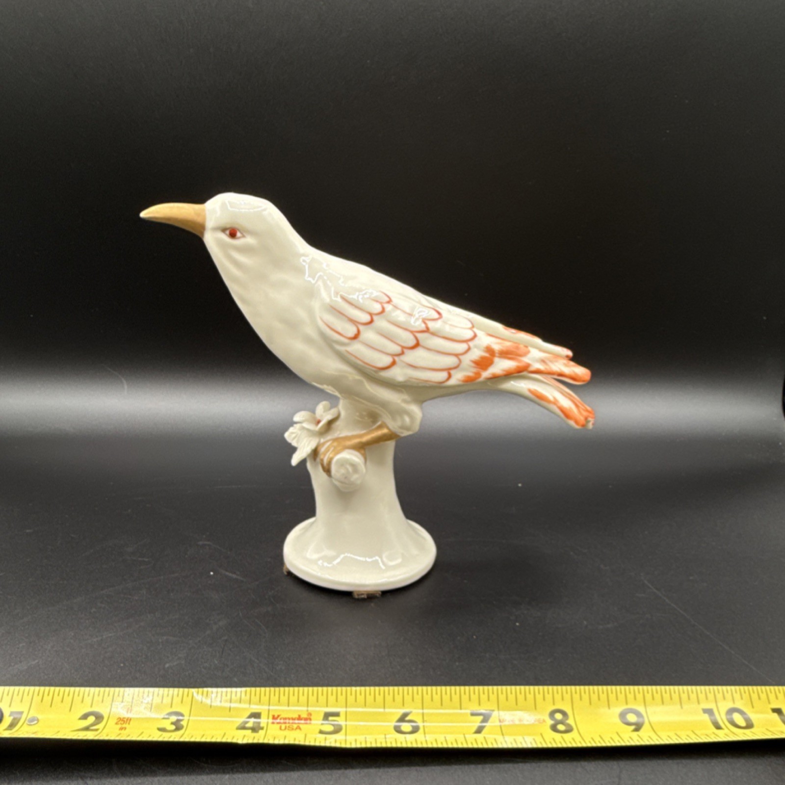 Porcelain bird figurine with orange and gold accents