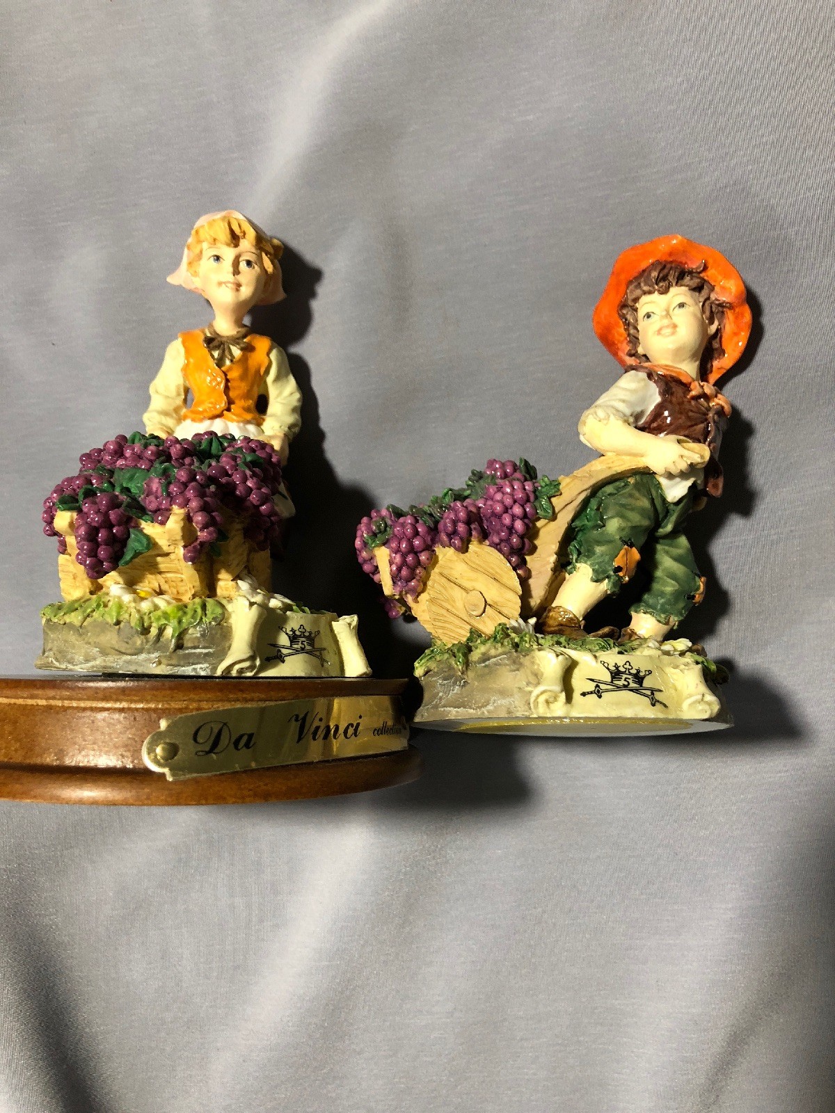 DaVinci Collection – A pair of Figurines – Boy and Girl with grapes in barrows
