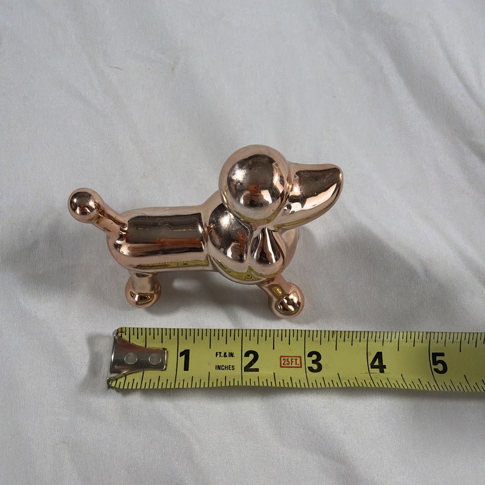 Ceramic metallic rose gold balloon dog figurine.