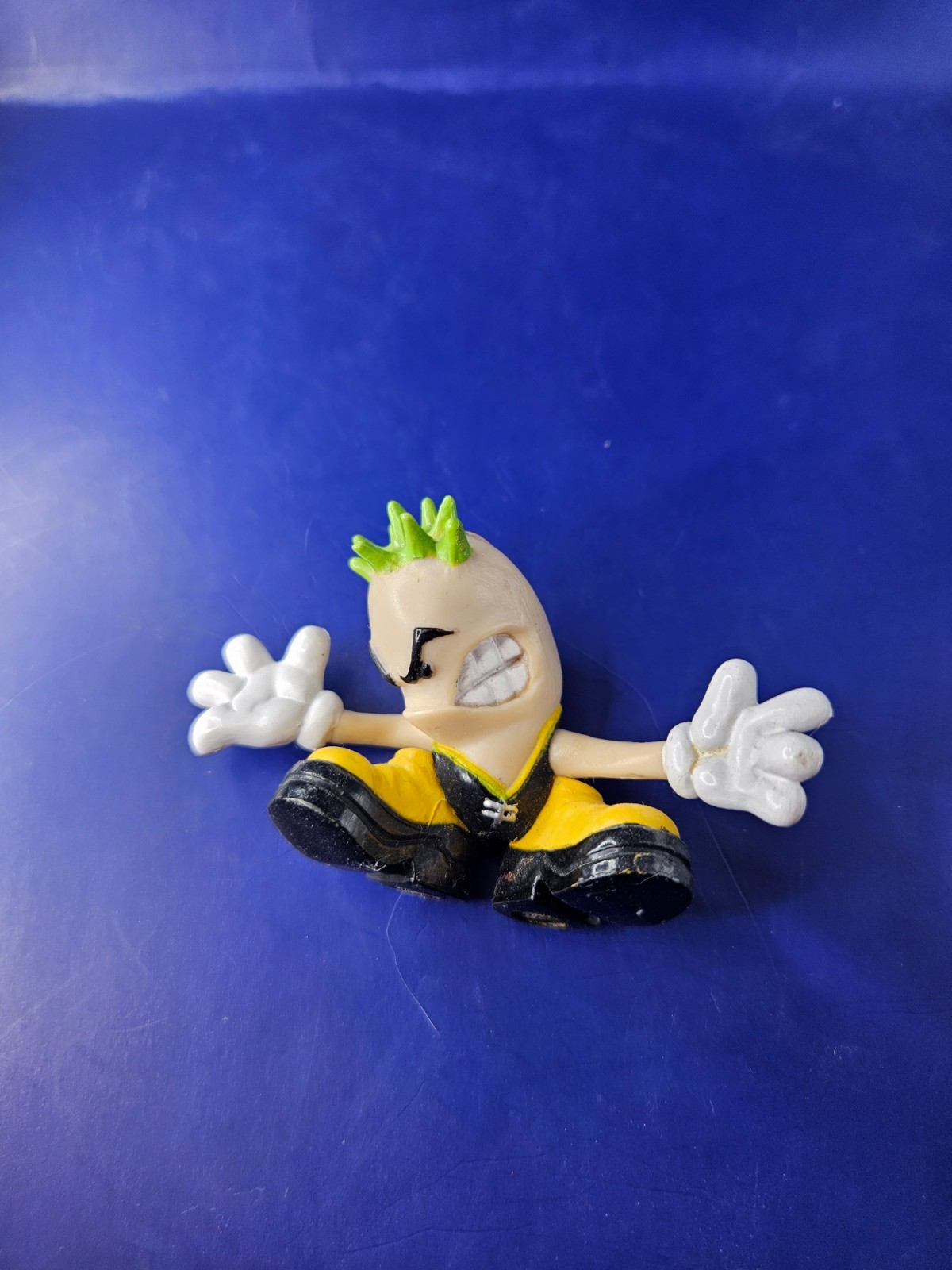 Stylized Collectible Figure – Green Mohawk Character with White Gloves