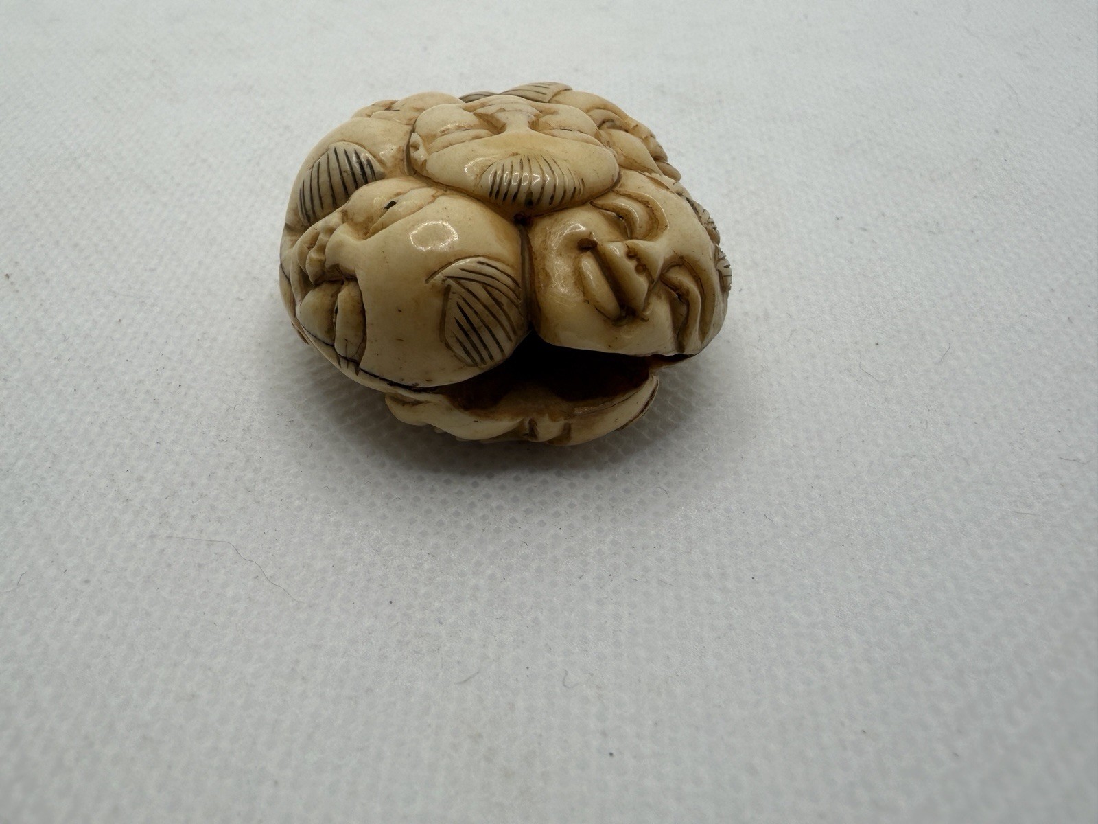 Japanese Carved Netsuke – Circular With Many Happy Faces And Geometric Shapes