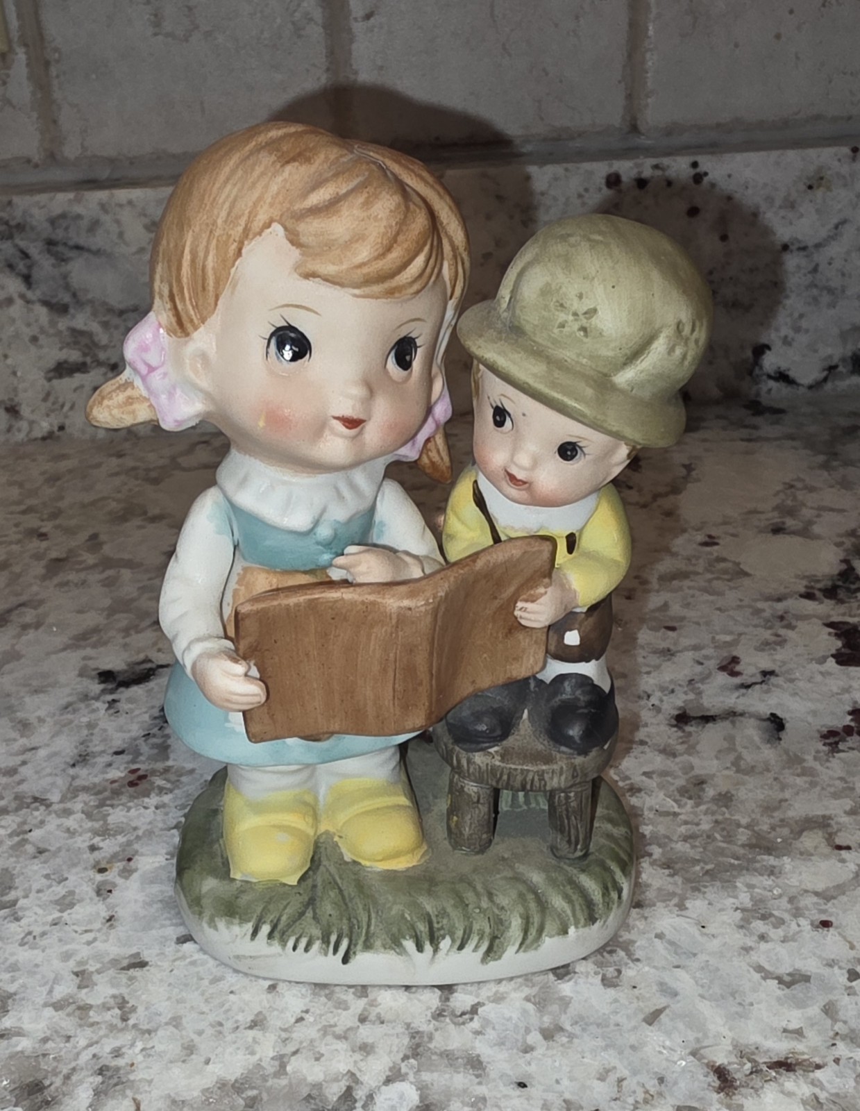 Vintage figurine, young girl reading to a boy “Artmark collectible”.