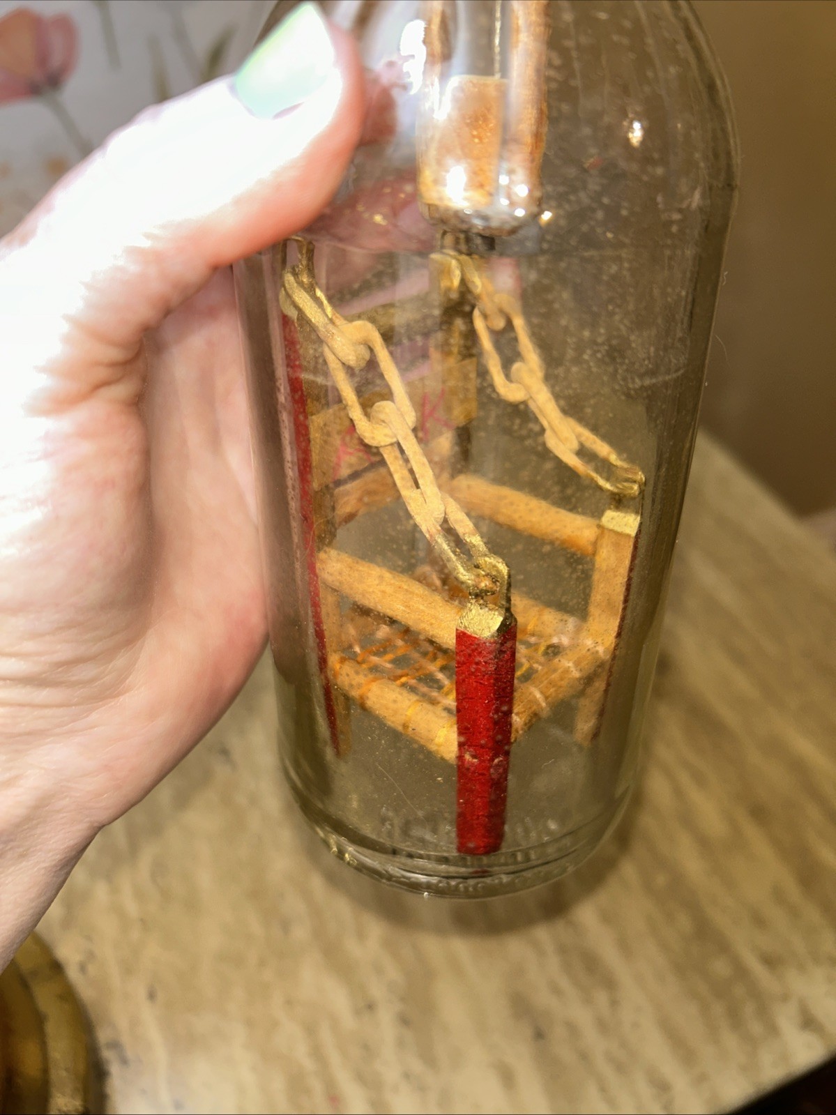 Handmade kinetic sculpture inside a glass bottle with ‘RK’ marking.