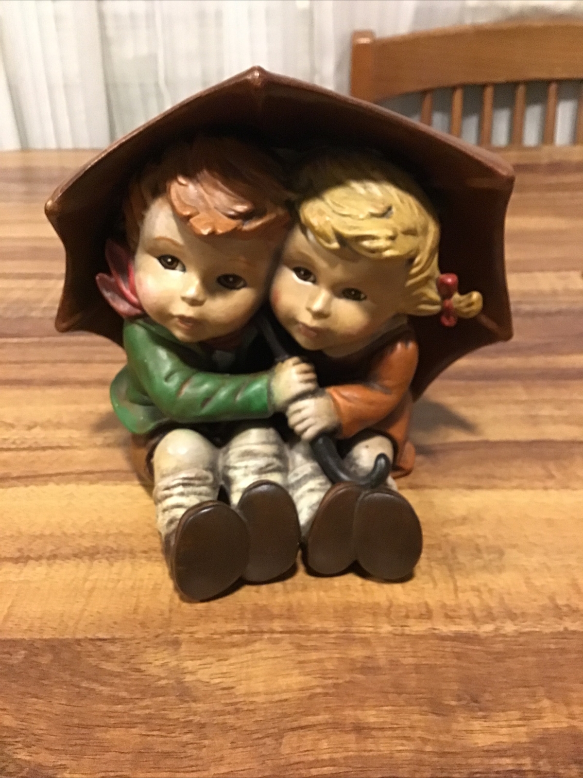 BOY AND GIRL SITTING UNDER BIG UMBRELLA 6″ TALL UNBRANDED