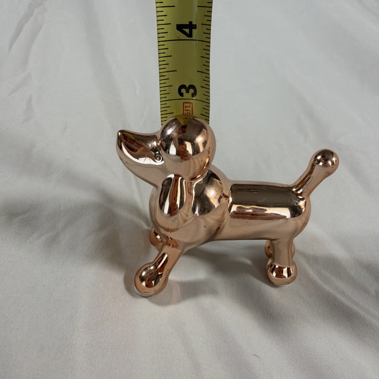 Ceramic metallic rose gold balloon dog figurine.