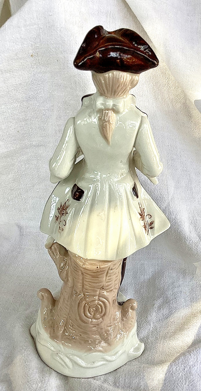 BAROQUE PORCELAIN GENTLEMAN W/ SWORD. LEANING ON A STUMP